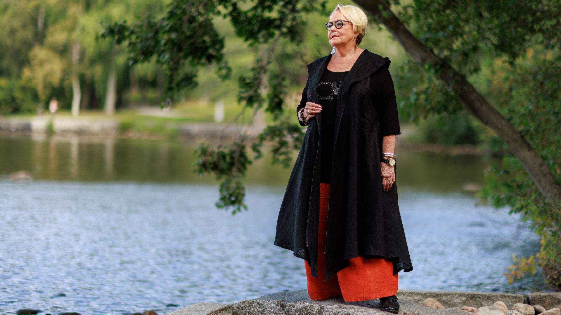 Woman standing on a rock by a lake