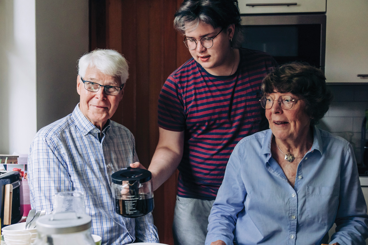 Elderly couple and teen age boy serving coffee