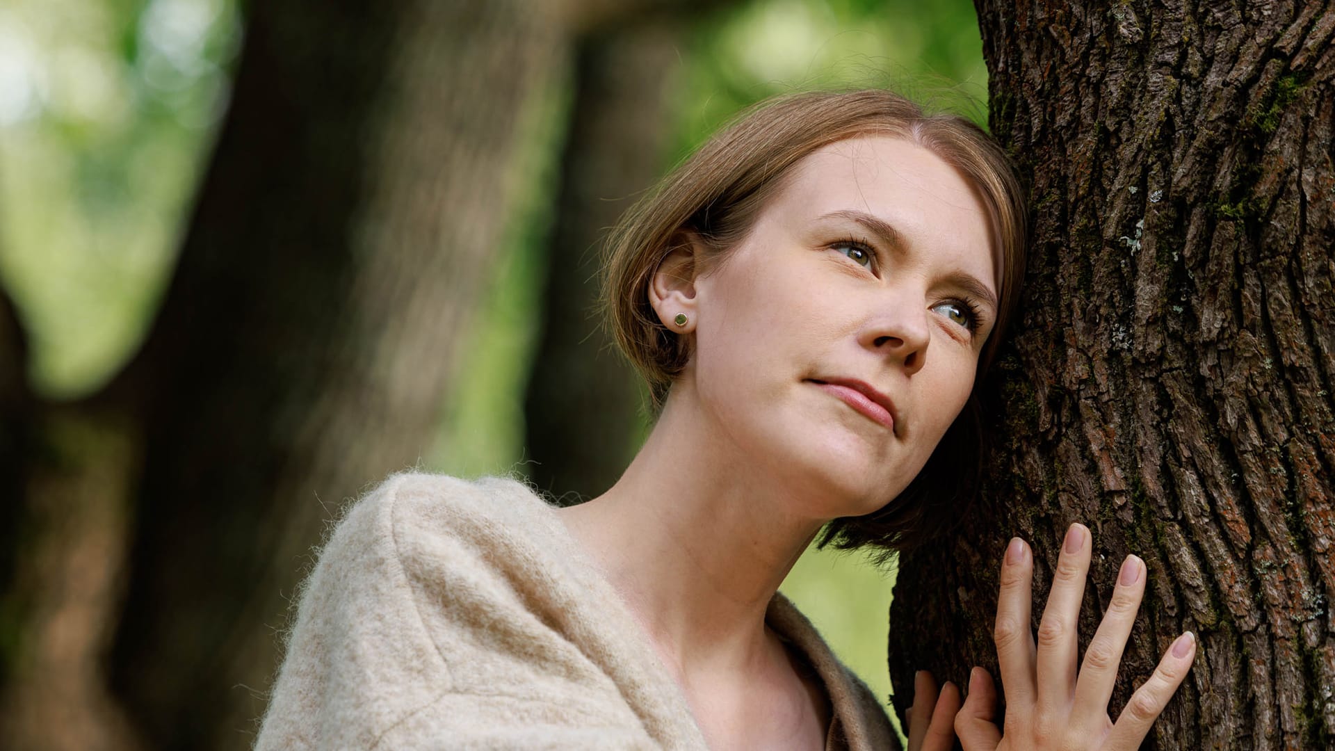 Woman leaning against a tree